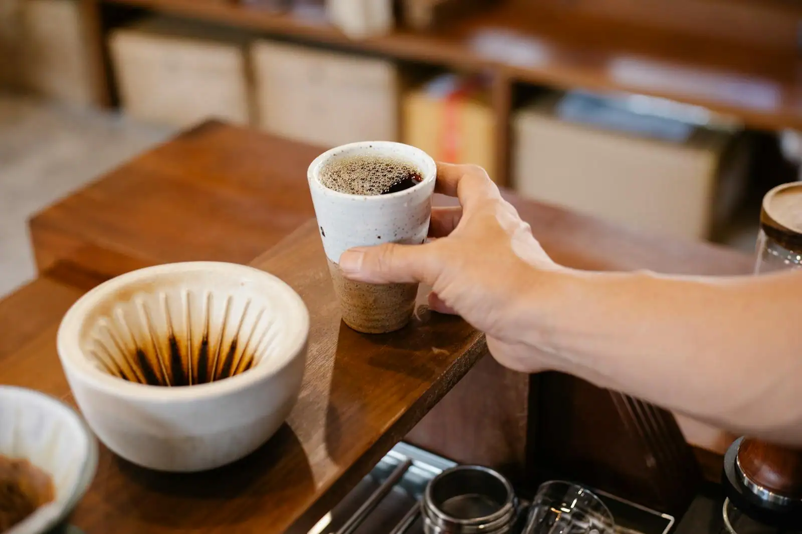 Tasse de café posée sur le comptoir en bois d'un café-restaurant lumineux et accueillant