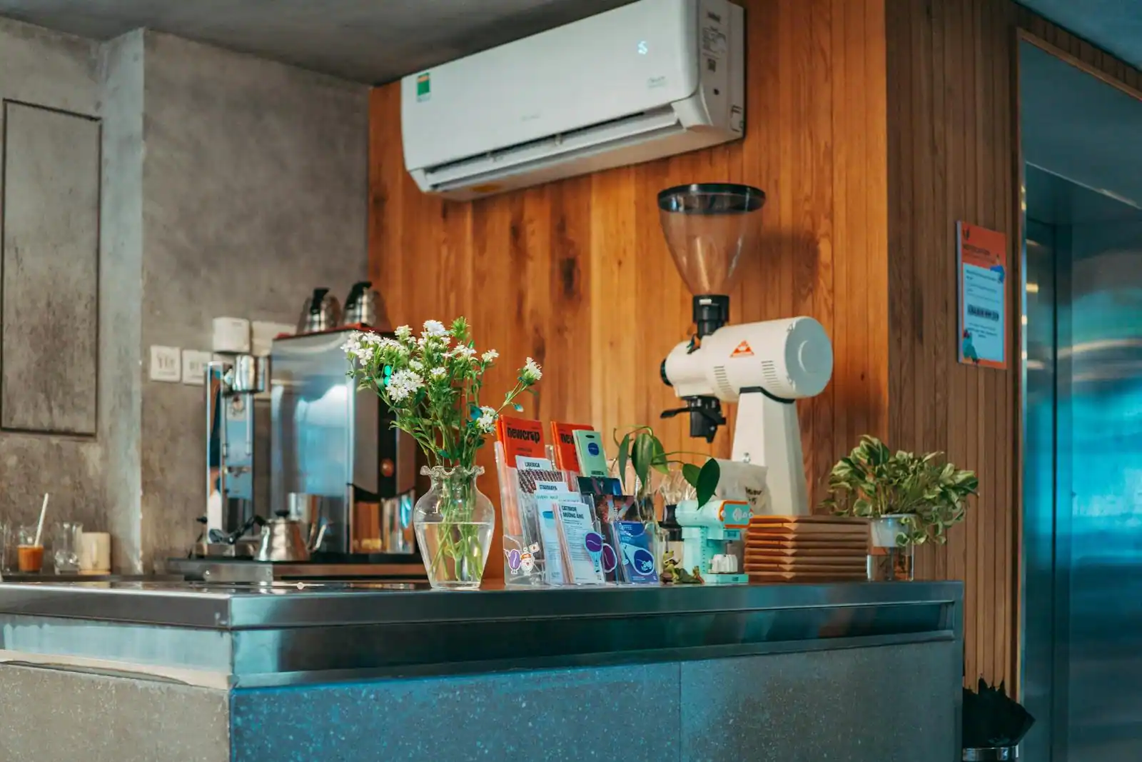 Intérieur chaleureux d'un coffee shop, un barista prépare un café au comptoir parmi les tasses