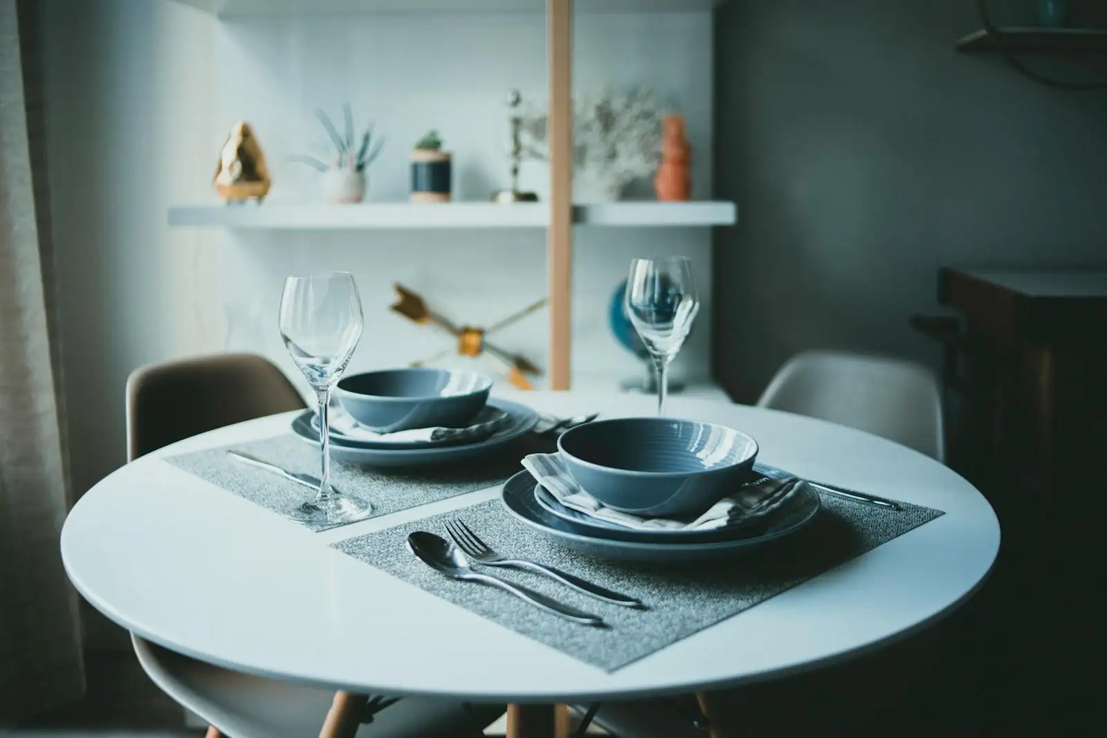 Table de réception dressée avec assiettes, verres à pied et couverts pour une grande tablée