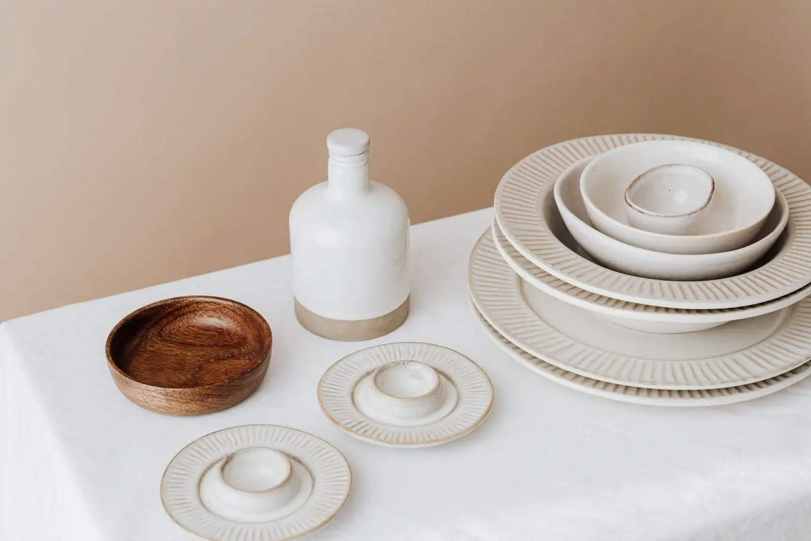 Table dressée avec une nappe en lin clair, assiettes et couverts disposés pour un repas