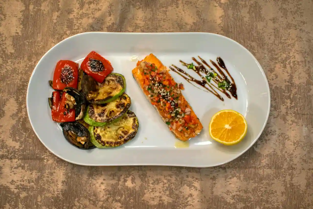 Assiette légère du soir composée de légumes vapeur, de poisson et d'herbes fraîches