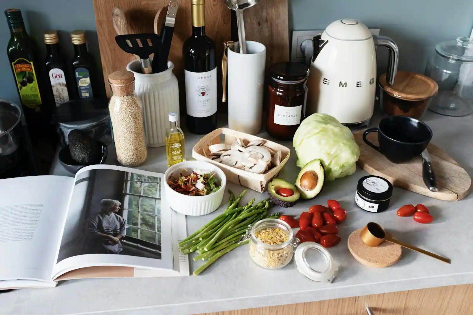 Plan de travail de cuisine avec légumes de saison, bocaux de fermentation et plats végétaux colorés