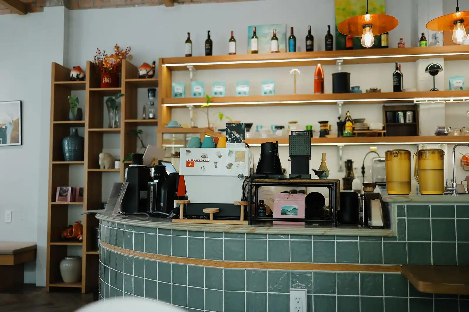 Comptoir carrelé d'un café de spécialité avec sa machine à expresso et son matériel.