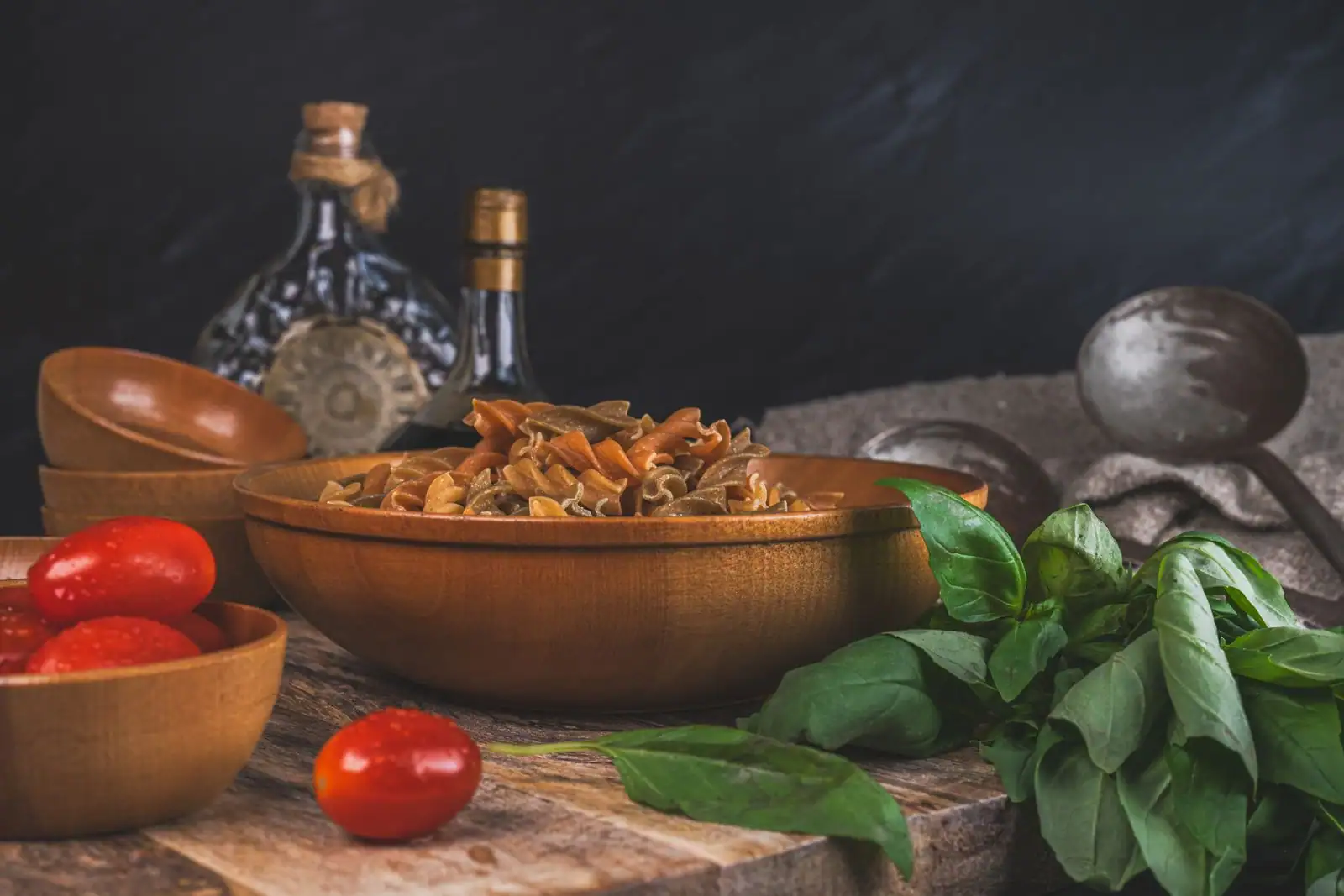 Bol de pâtes sèches, tomates cerises et basilic frais avec de l'huile d'olive, ingrédients de la cuisine italienne.