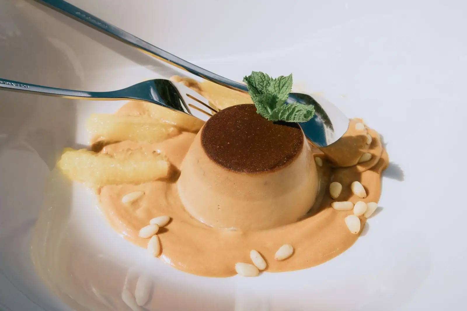 Dessert individuel nappé de caramel, décoré de menthe fraîche