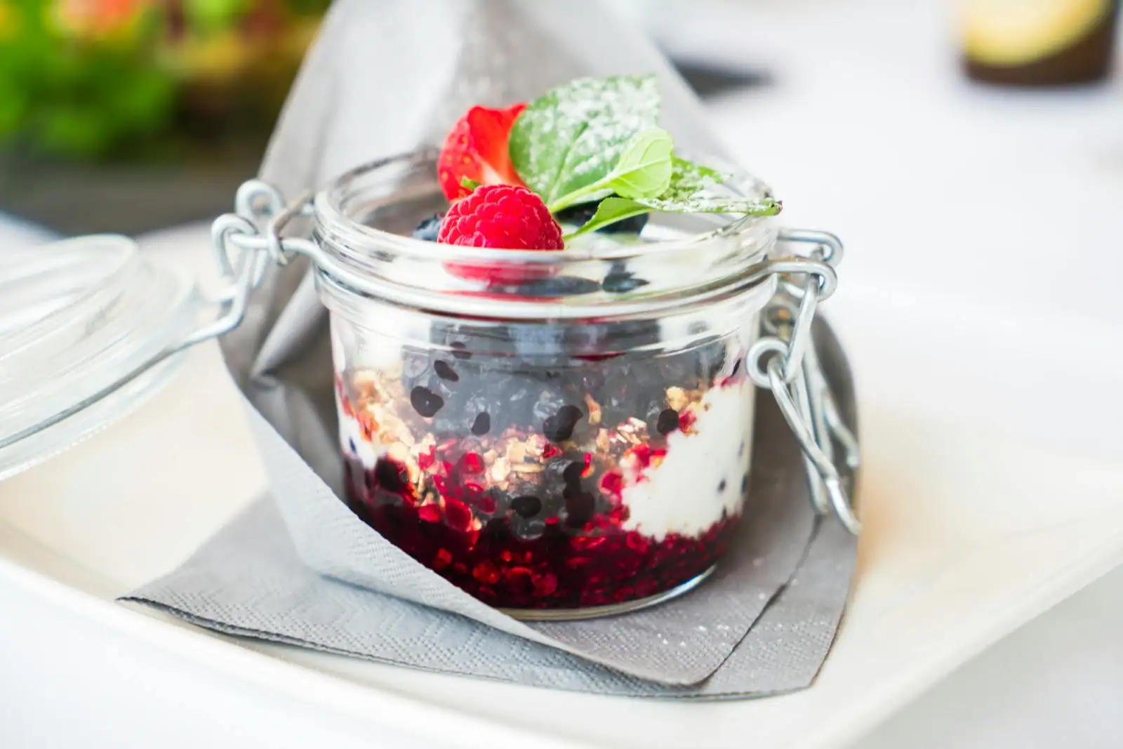 Verrines de dessert au fromage blanc et fruits frais sur une table claire