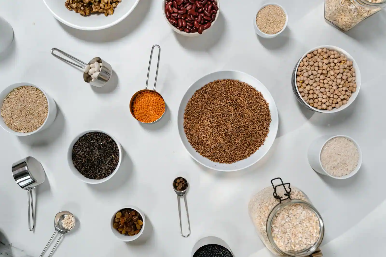 Bols de légumineuses et de céréales variées (lentilles, pois chiches, riz), bases d'une alimentation végétarienne et vegan.