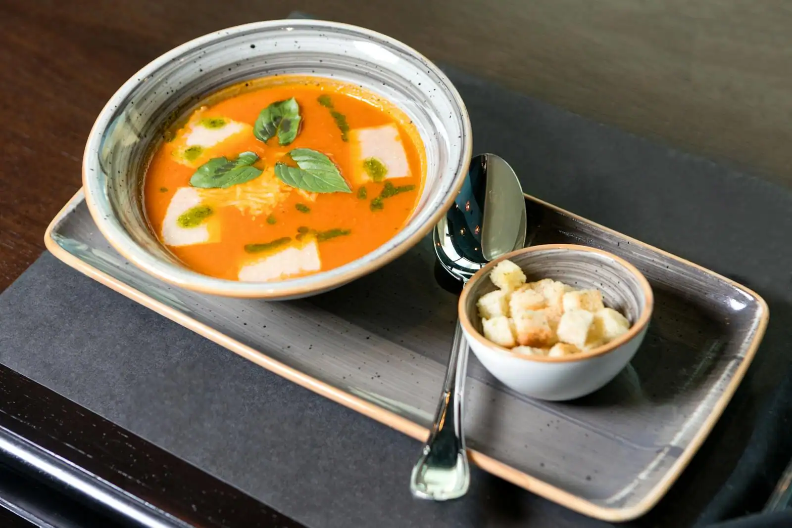 Velouté de légumes fumant servi dans un bol garni d'herbes