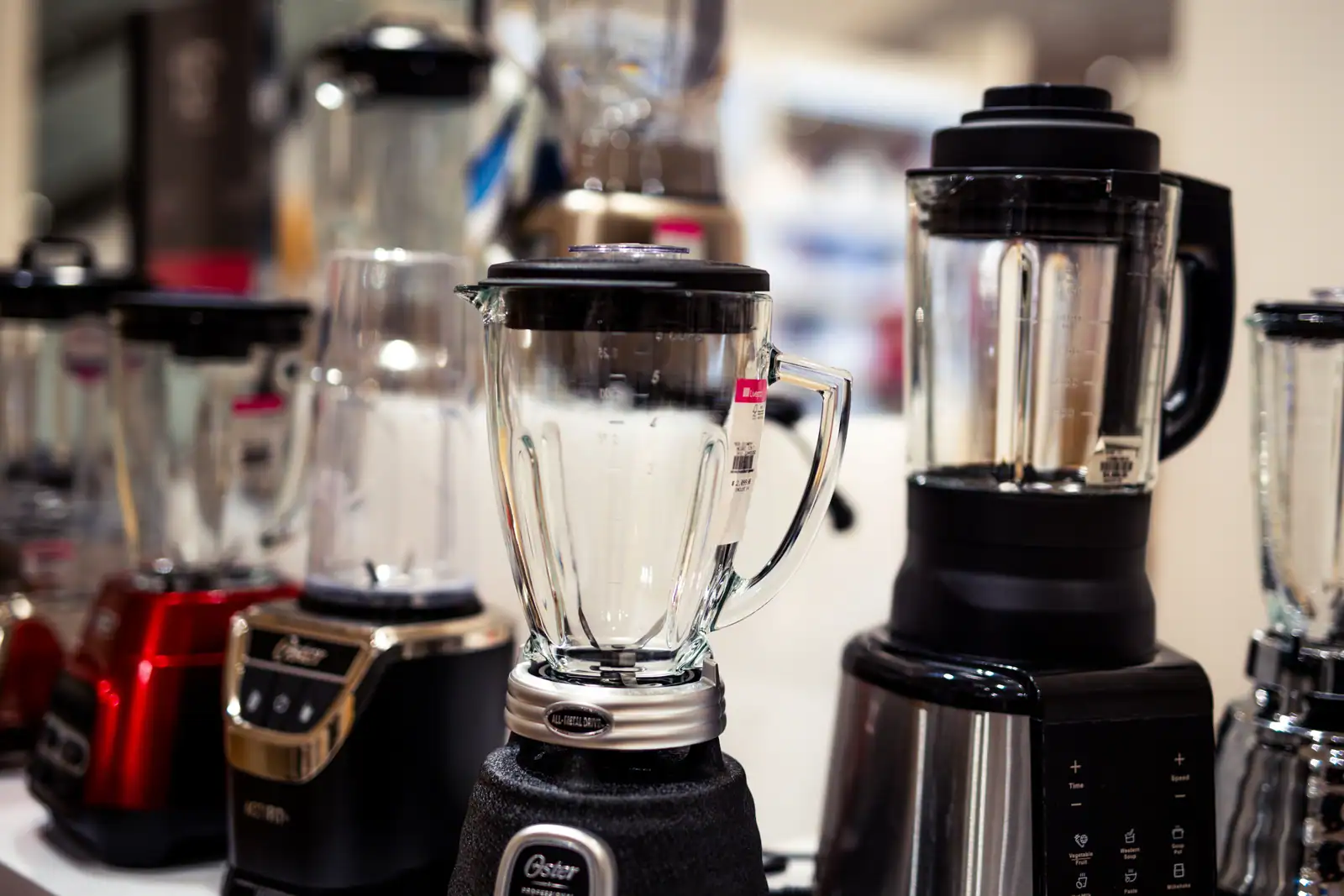 Plusieurs modèles de blenders de cuisine exposés côte à côte, bols en verre et socles moteur