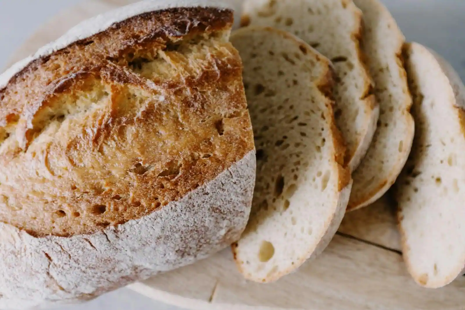 Pain de campagne rond partiellement tranché sur une planche en bois