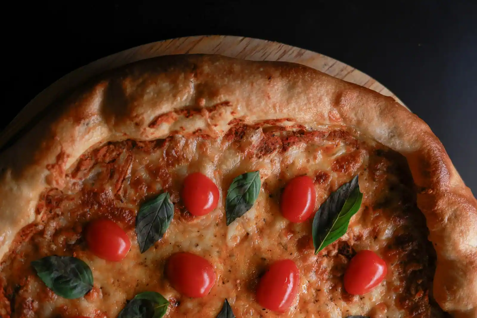 Pizza margherita maison à la croûte dorée, garnie de mozzarella, de tomate et de basilic frais