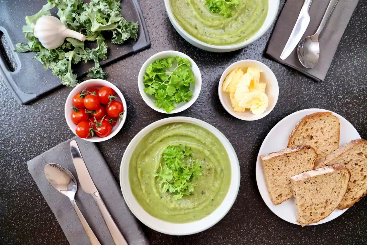 Un bol de soupe de légumes d'hiver entouré de légumes de saison, une recette saine et réconfortante.