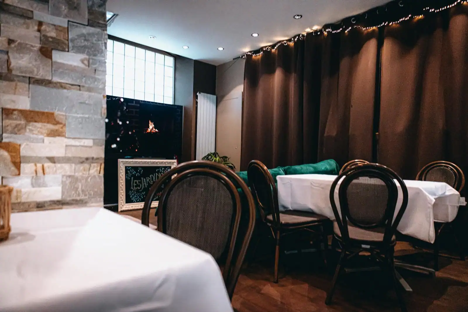 Salle d'un bistrot contemporain dressée pour le service, ambiance chaleureuse
