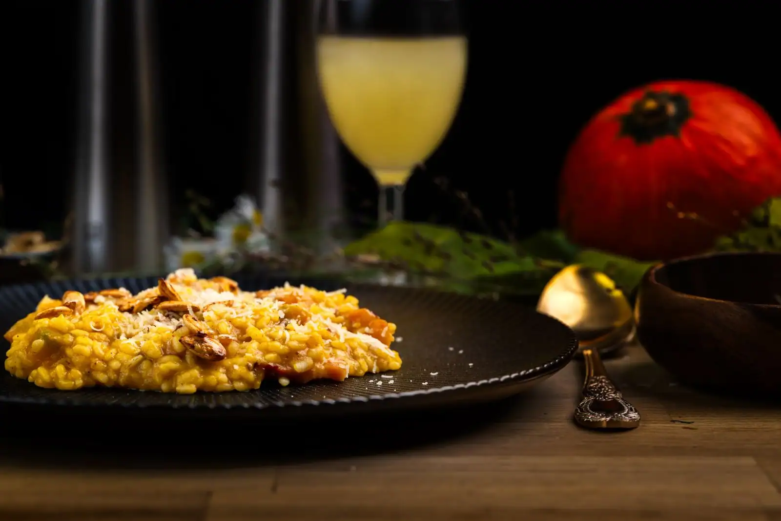 Assiette de risotto crémeux au potimarron parsemé de parmesan et de graines grillées