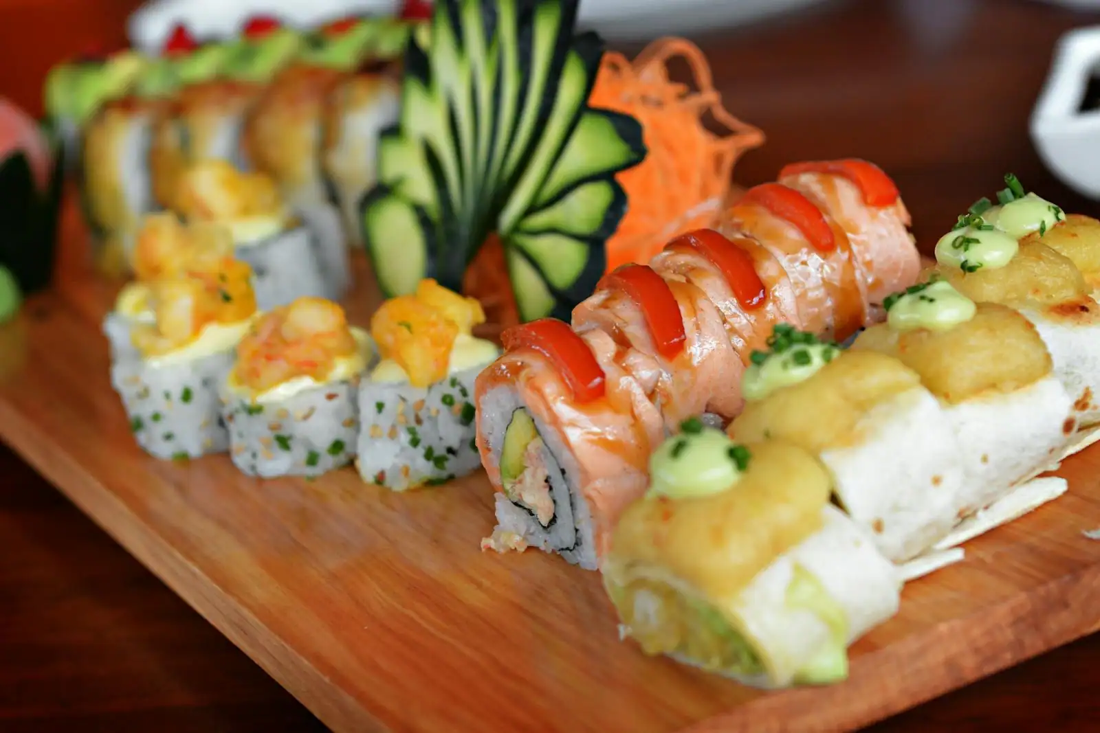 Assortiment de makis et de sushis maison disposés sur une planche en bois, prêts à servir