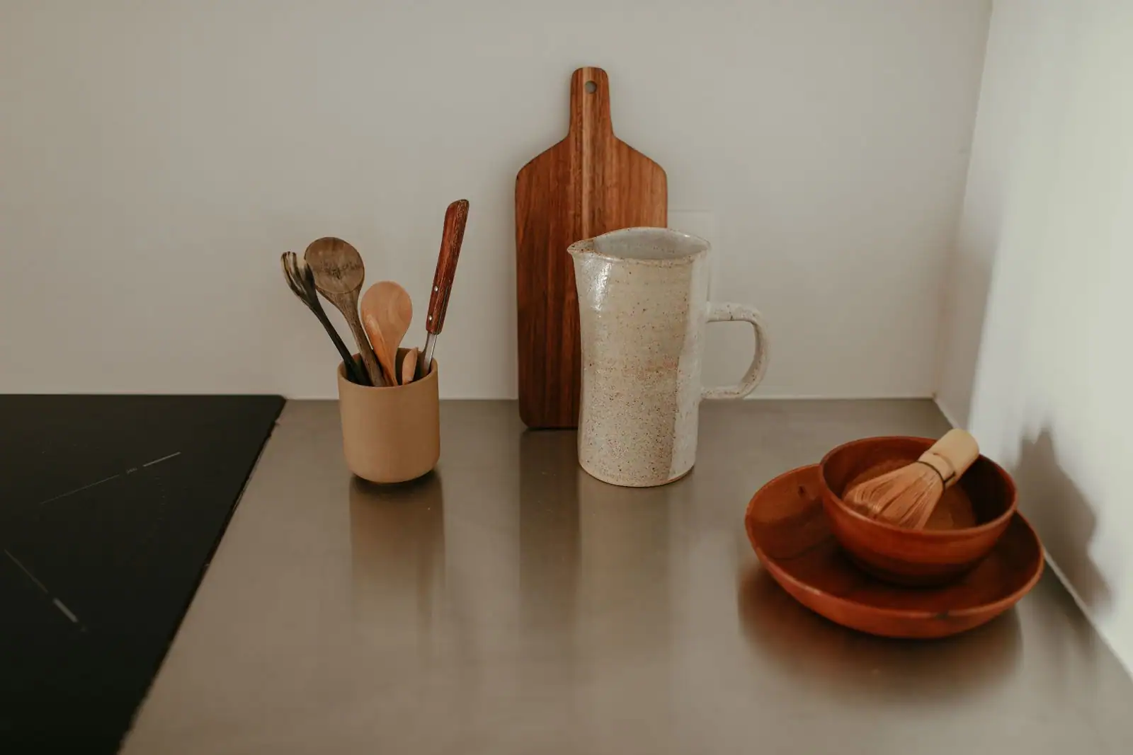 Ensemble d'ustensiles de cuisine en bois rangés dans un pot sur un plan de travail