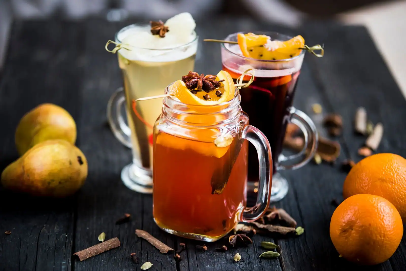 Verres de vin chaud épicé garnis de rondelles d'orange, de cannelle et d'anis étoilé