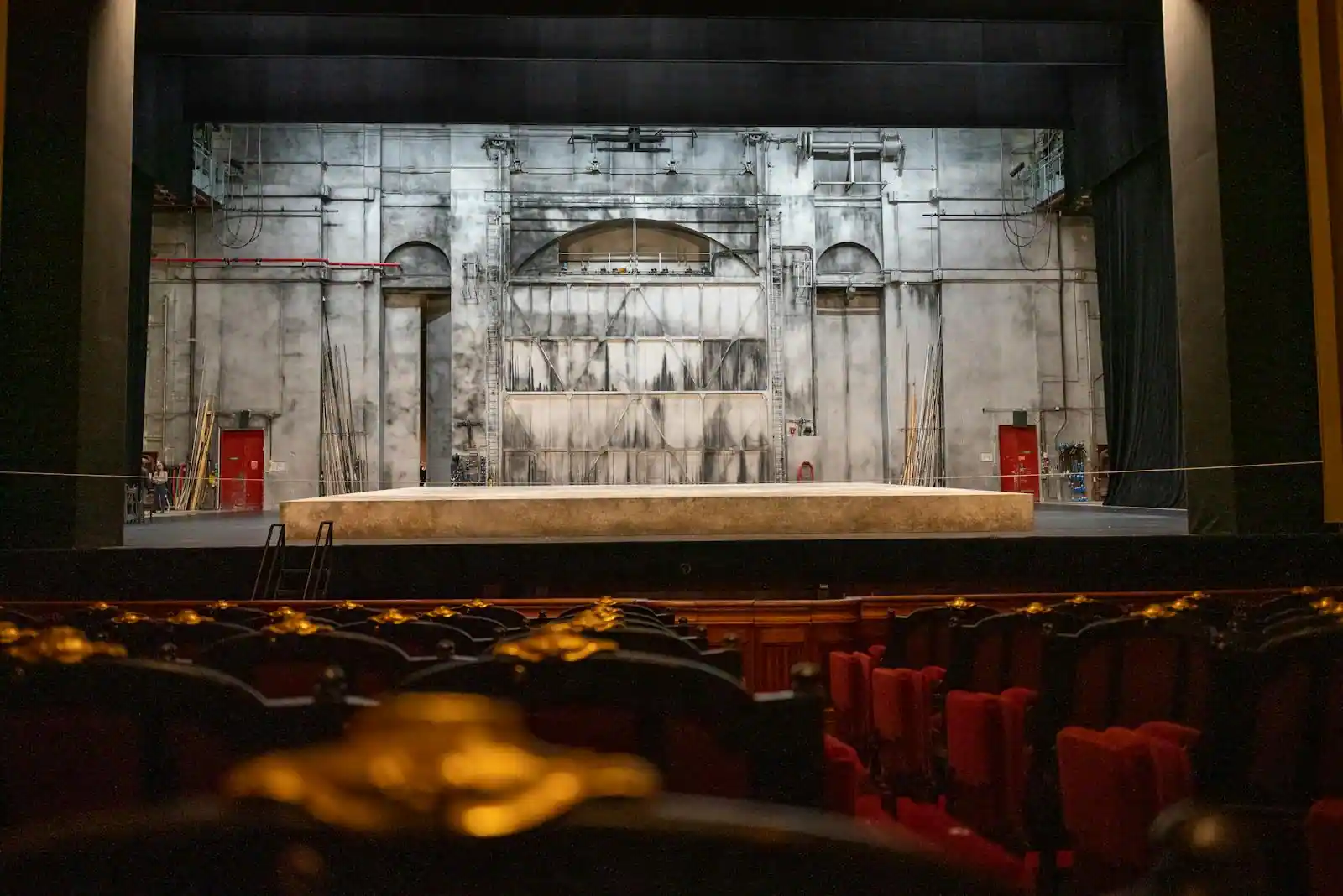 Scène de théâtre vide aux rideaux rouges, sous les projecteurs