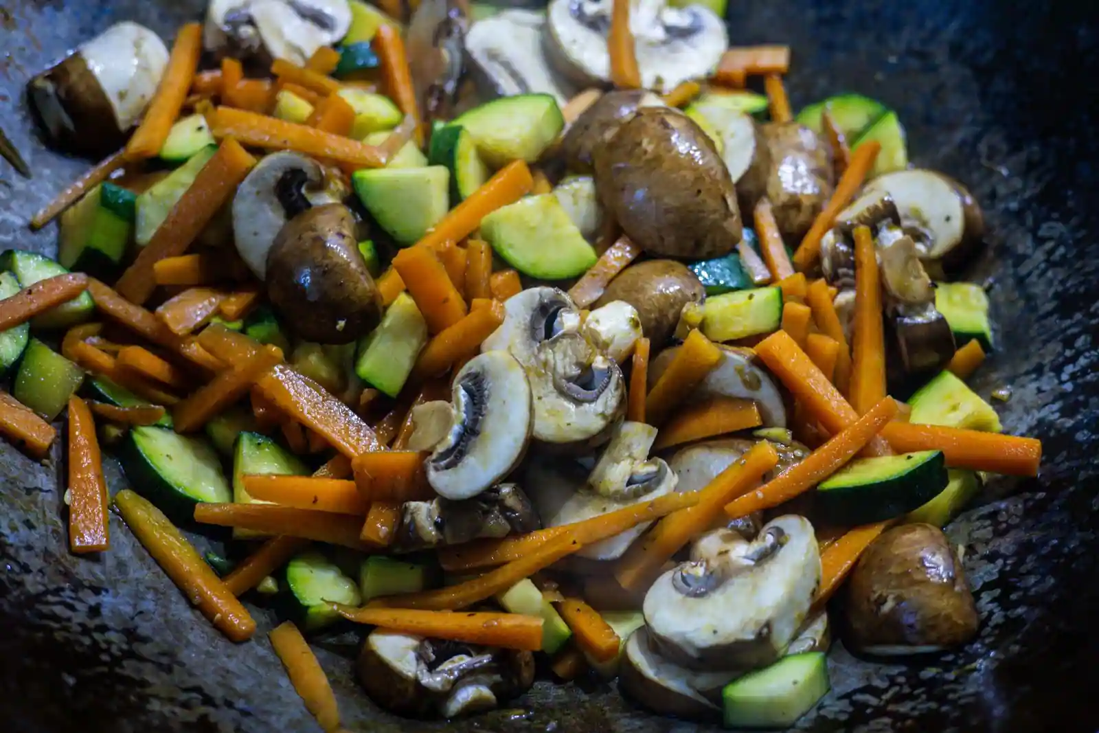Des légumes sautés à feu vif dans un wok.