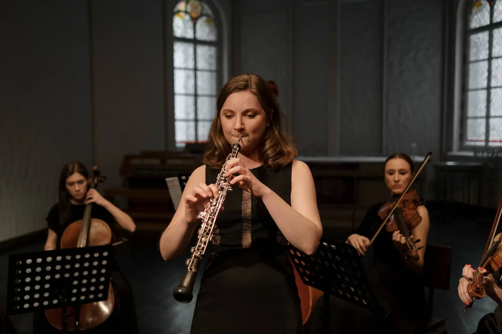 Hautboïste jouant de son instrument au sein d'un ensemble à cordes lors d'un concert de musique classique