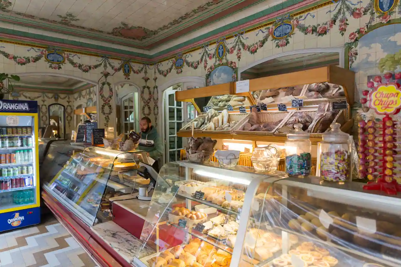 Intérieur de boulangerie française : pains étiquetés sur les étagères et vitrine de viennoiseries