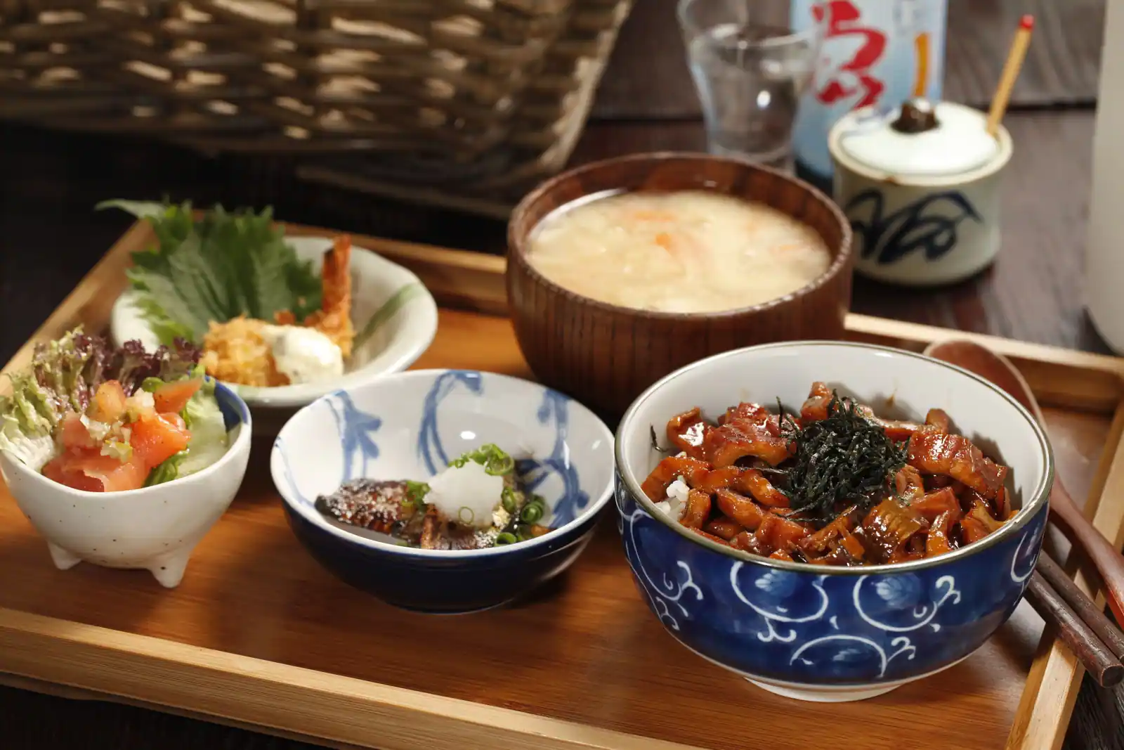 Plateau japonais en bois : bol de riz garni, soupe, salade et petites préparations en bols séparés